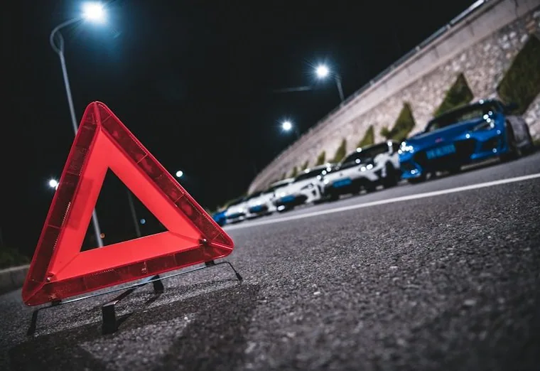 a hazard triangle behind a broken-down car